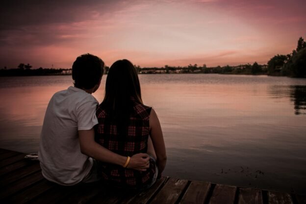 man and woman sitting on dock